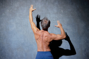 ポーズをとる筋肉のあるシニアの男性　後ろ姿