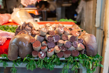 Close-up of blood sausages displayed on the counter of the market butcher shop. Black pudding.
