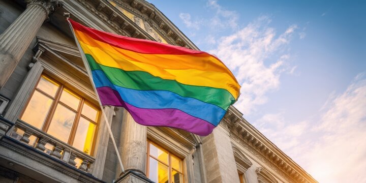 The Rainbow Flag Flying Proudly Over a Historic Building at Golden Hour - Powered by Adobe