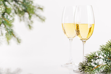 Champagne glasses and snowy fir on white