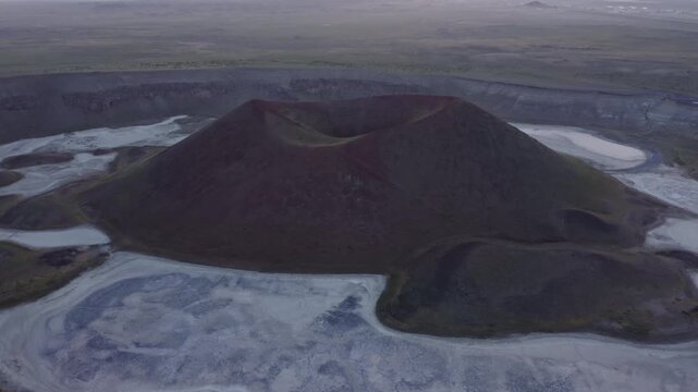 Aerial view of volcanic cone with crater and dried lake at sunset, Turkey