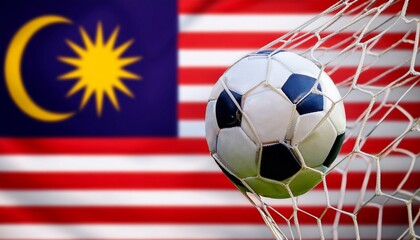 soccer ball with the goal net; Malaysia flag blurred in the background