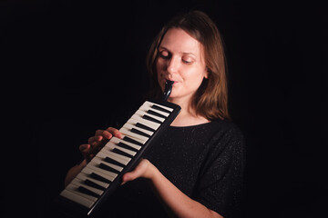Woman musician playing a melodica, looking focused and enjoying music. Creative musical expression...