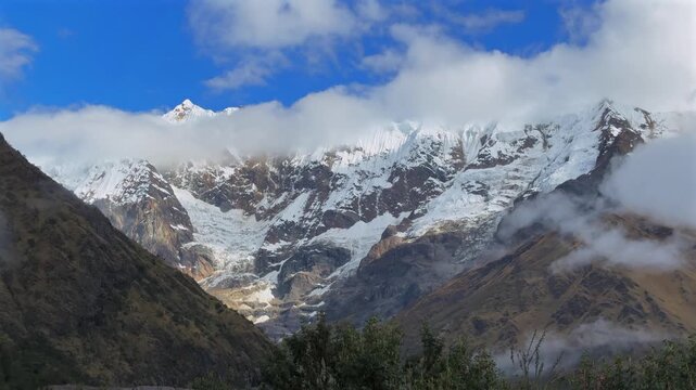 Mount Humantay Peruvian Andes snow capped glacier mountain Salcantay Inca trail trek Peru aerial drone low fog clouds rainy dry season Laguna Humantay Soray Anta Provience Cusco pan left motion