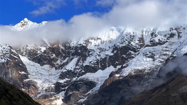Mount Humantay Peruvian Andes snow capped glacier mountain Salcantay Inca trail trek Peru aerial drone pan left motion low fog clouds blue sky rainy dry season Laguna Humantay Soray Anta Cusco region