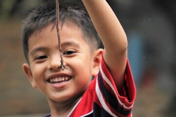 portrait of a boy in the park with earthworm