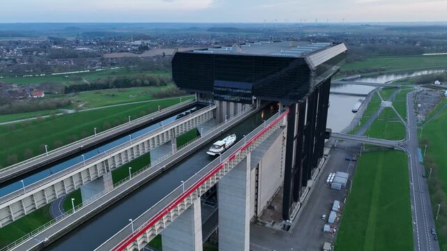 Zoom in revealing a boat moving across the upper canal of the Str&eacute;py-Thieu boat lift in Le Roeulx at blue hour
