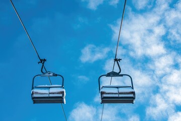 Two ski lift chairs ascend against a bright blue sky