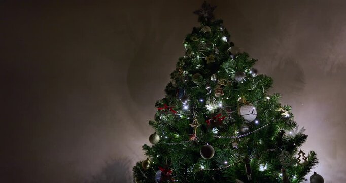Decorated Christmas tree with silver baubles, wooden reindeer ornaments with red ribbons, ballerina and mouse toys, glowing fairy lights and bead garlands. Christmas tree decorations