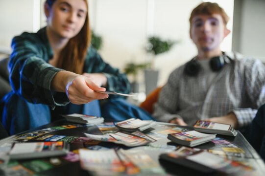 Friends playing card game at home, choosing strategy, having fun