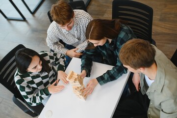 Friends playing wooden block game in coworking space