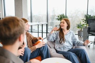 Coworkers playing guessing game with sticky note on forehead in office