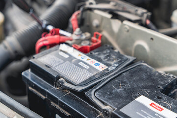 Car battery repair work taking place in an auto shop during the day