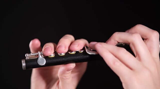Woman playing a piccolo flute. Musician performing classical instrument with skill. Professional concert music performance and artistic talent concept.