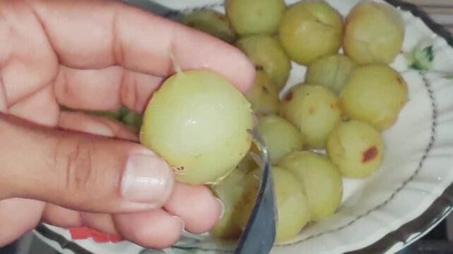 piercing boiled indian gooseberries for deep syrup infused murabba preparation