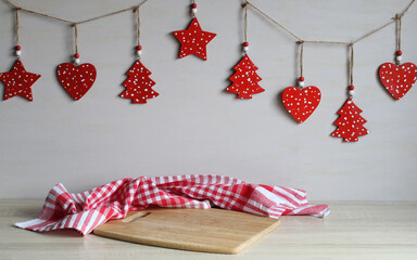Wooden christmas decorations hanging above chopping board. New Year's backdrop for greeting postcards