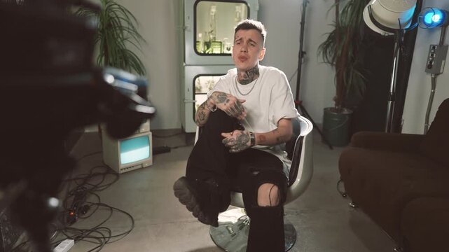 Arrogance and narcissism self-confident rap artist reading rap to camera. Portrait of handsome caucasian hip-hop singer recording musical video or content for social media, tattoos on face and body