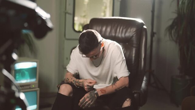 Self-confidence and self-expression by music, male rap artist singing song. Portrait of handsome cool guy with tattoos on face and body, filming musical video of hip-hop singer, be yourself and unique