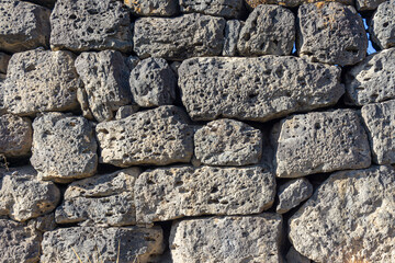 Laying a wall of uneven dark gray stones of different sizes