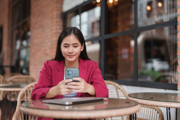 Young asian woman using smartphone at outdoor cafe