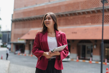 Young businesswoman holding digital tablet standing outdoors