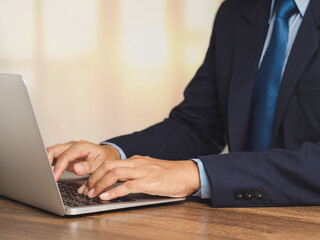 Businessman working on laptop at office desk.