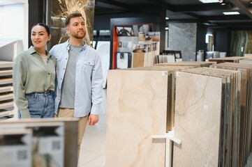 Couple choosing ceramic tiles in a store for home renovation