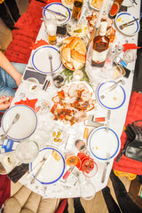 Overhead shot of a holiday dinner table with roasted meat and drinks