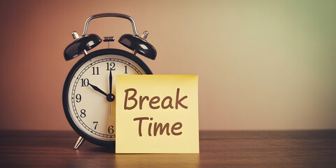 Vintage alarm clock with yellow sticky note saying 'Break Time' signals a welcome pause in the busy workday, perfect for relaxation themes.