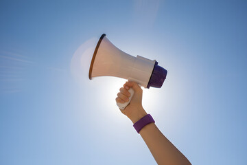activism and protest symbolism with person lifting megaphone outdoors