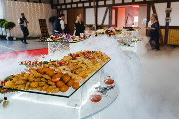 Elegantes Festbuffet mit kunstvoll dekorierten Speisen und Nebeleffekt