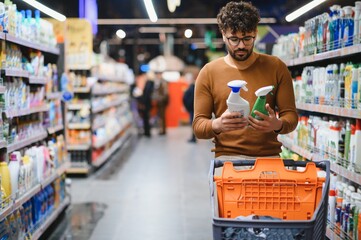 Arab man choosing cleaning products in supermarket