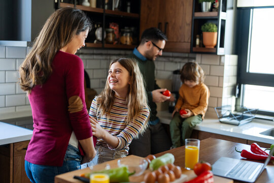 A happy family is cooking together in a bright kitchen, showing joy, teamwork, and love at home