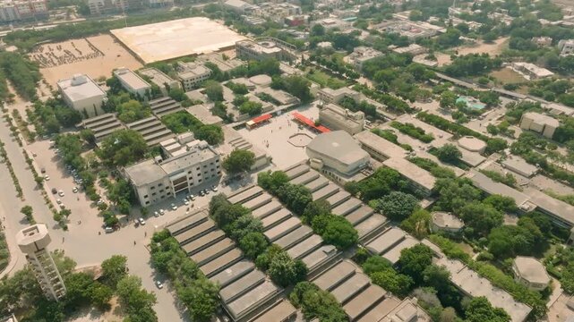 Receding and ascending aerial footage, angled down over the campus of NED University of Engineering and Technology in Karachi, with the hazy, sprawling city visible in the background.