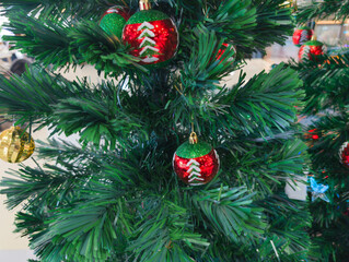 A detailed view of a lush green Christmas tree decorated with glistening red and gold baubles, capturing the essence of holiday warmth and festive cheer for seasonal celebrations