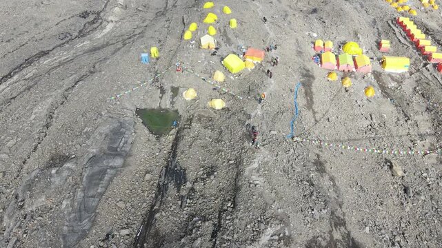 Drone footage showcases Manaslu Base Camp below the 8,163m Himalayan peak. The scene reveals snowy ridges, rugged terrain, and the dramatic high-altitude environment of this remote mountain region.