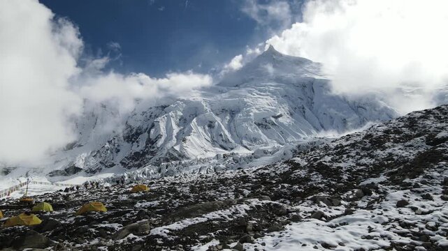 Drone footage showcases Manaslu Base Camp below the 8,163m Himalayan peak. The scene reveals snowy ridges, rugged terrain, and the dramatic high-altitude environment of this remote mountain region.