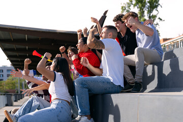 Diverse friends celebrating a goal, watching a sporting event in a stadium. Fans supporting their team with enthusiasm