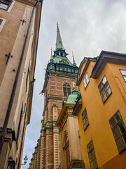 historic church tower between narrow buildings