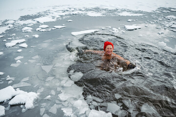 Elderly woman practicing outdoor ice bathing during winter season
