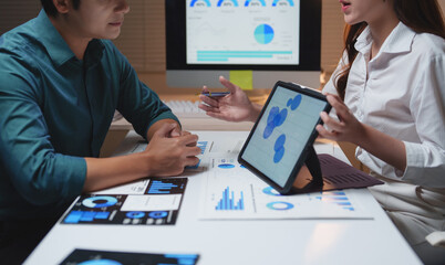 Business colleagues analyzing financial dashboard data in office