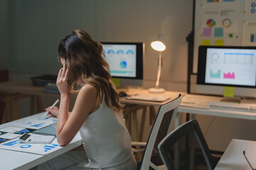 Businesswoman analyzing financial data and working overtime in office