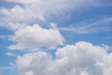 Obraz premium A blue sky filled with fluffy white clouds. Background.