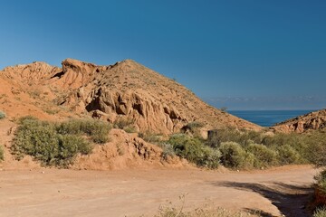 View of Fairytale Canyon (Canyon Skazka) and Issyk Kul Lake. Kyrgyzstan. Asia.