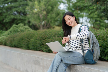 Young woman checking smartwatch while working outdoors