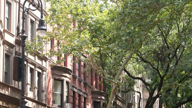 New York City townhouse buildings, brownstone row houses in Manhattan or Brooklyn, United States of America. Classic buildings on residential district street. Real estate property. Rowhouse townhome.
