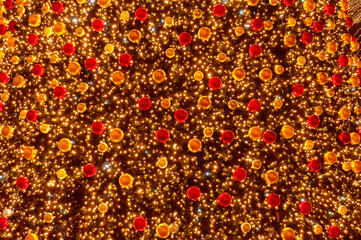 Christmas tree with dark background glowing lights. Multicolored lights decorations as background.