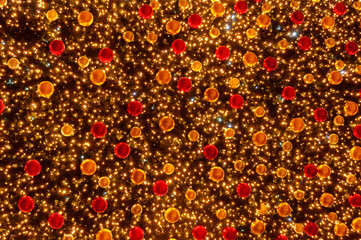 Christmas tree with dark background glowing lights. Multicolored lights decorations as background.
