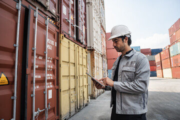 Man logistics workers use tablet computer with container background	