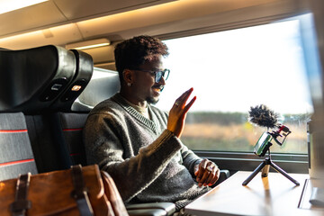 Man vlogging on train during video call business trip